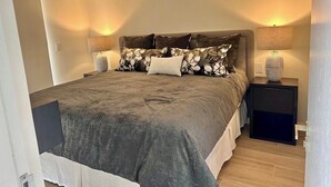 A bedroom with a bed, nightstands, and lamps. - New Ocean View Beach Front Deluxe Condo! (Jaco)