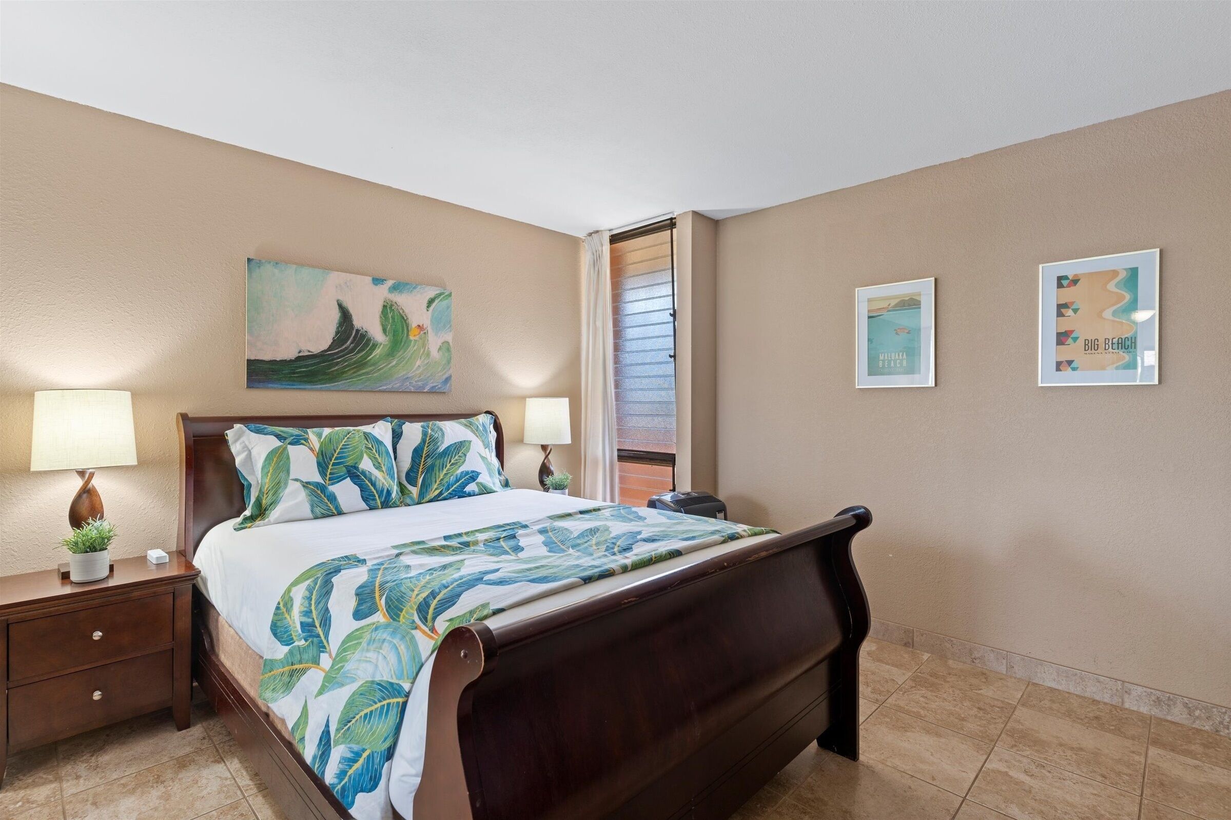A hotel room with a bed, nightstands, a window with blinds, and wall art.