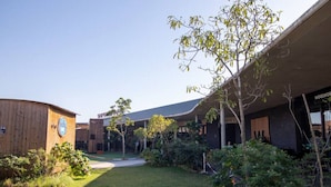 Un patio con un área verde, un edificio de madera y una estructura moderna con un letrero que dice "WOOLWORKS".