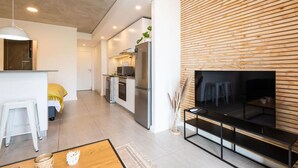 A modern living space with a kitchen, dining area, and a fireplace. - Coral Point Executive Studio Apartment E316 (Sibaya Precinct)
