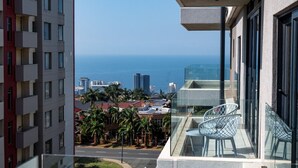 A balcony with a glass railing overlooking a cityscape and the ocean. - Luxury Bellagio 303 (uMhlanga Ridge, KwaZulu-Natal)