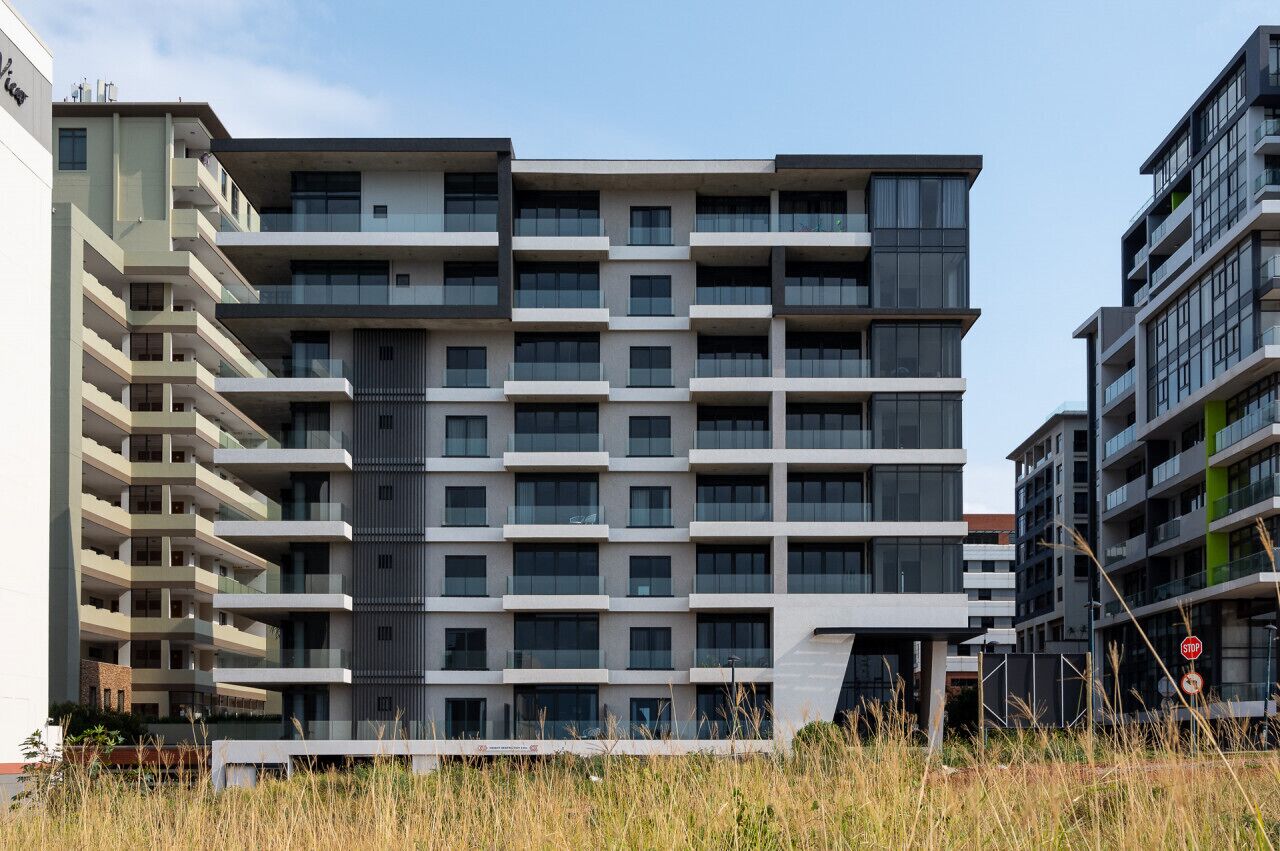 A multi-story residential building with balconies, a flat roof, and a modern architectural style.