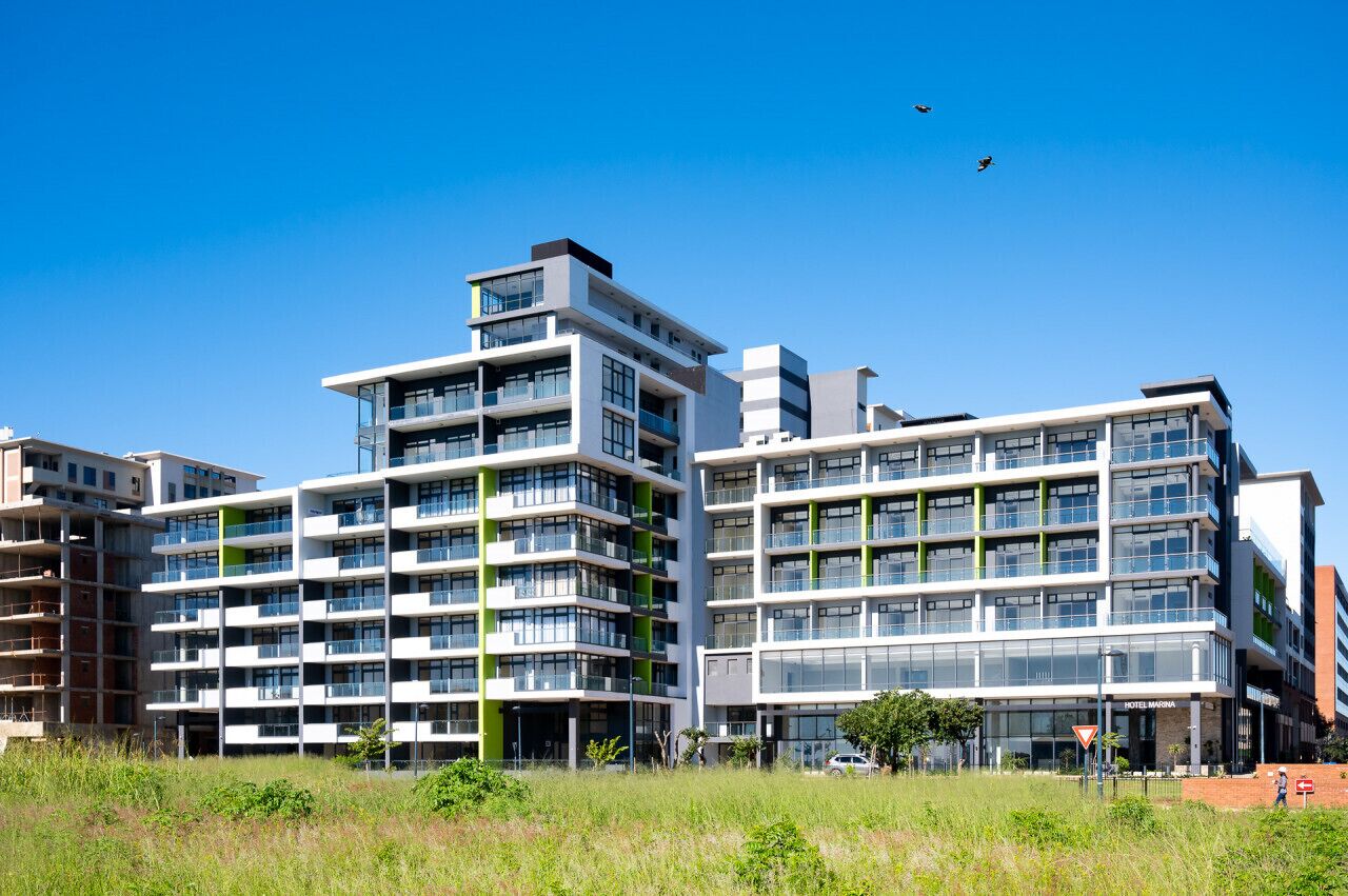 Een modern hotel met meerdere verdiepingen, een glazen gevel, diverse balkons en een centrale binnenplaats.