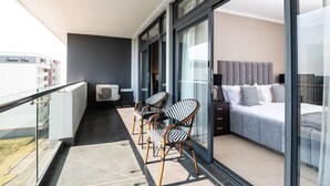 Ein Balkon mit einem Bett, einer Couch und zwei Stühlen.