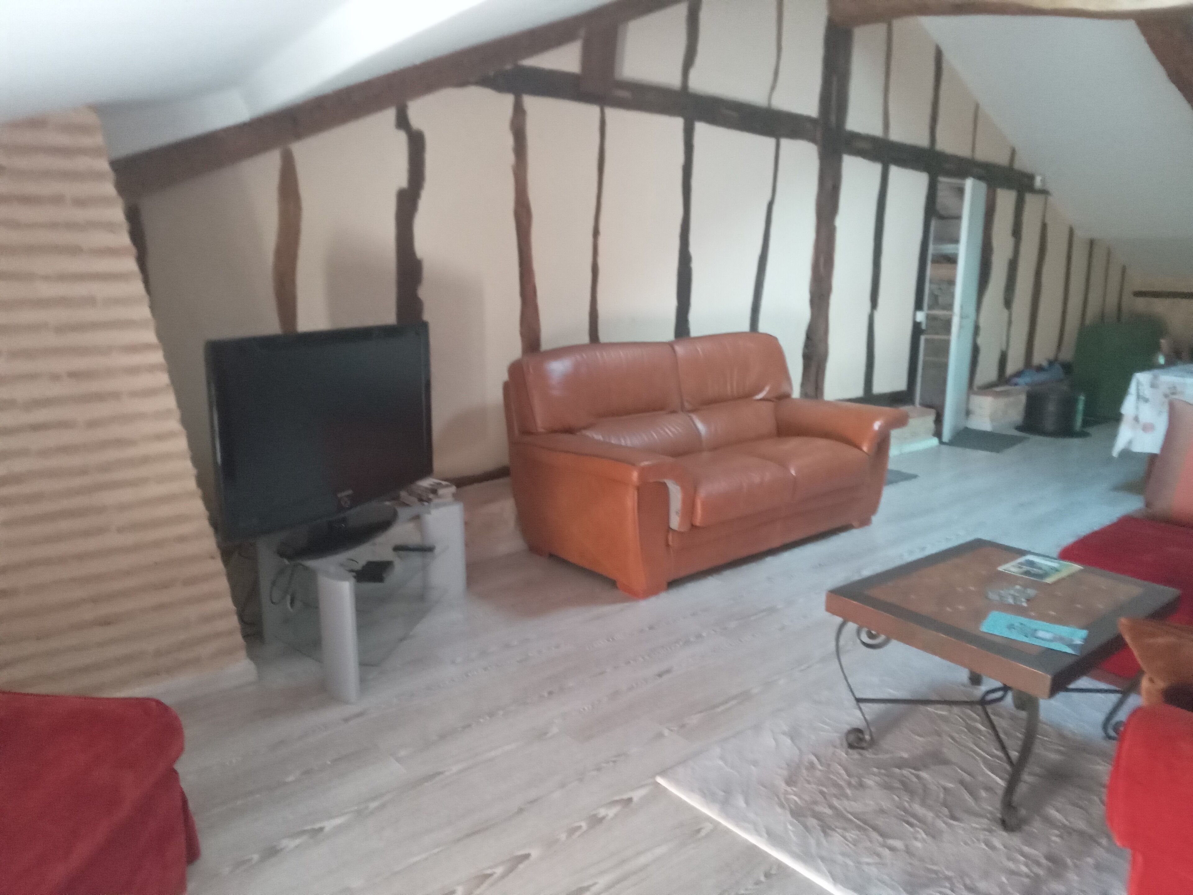 Una sala de estar acogedora con un sofá de cuero, un televisor de pantalla plana y una mesita de centro.