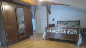 Un dormitorio con una cama de madera, un armario y una puerta.