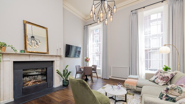 Una sala de estar moderna con chimenea, asientos cómodos y un comedor.