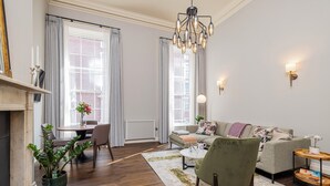 Una sala de estar con un sofá, sillones, una mesa de centro, una chimenea y un comedor con sillas y una mesa.