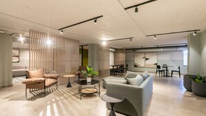 A modern interior with a sectional sofa, a round coffee table, and a dining area with a table and chairs.