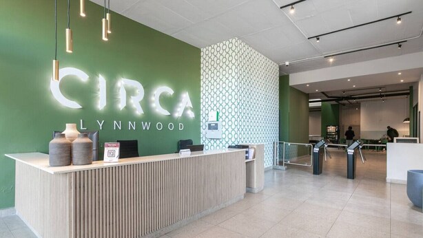 A modern reception desk with a green wall and a sign that reads "CIRCA LYNNNWOOD".