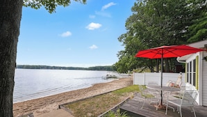 A deck with outdoor furniture overlooking a lake.