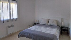 A bedroom with a bed, two bedside tables, a window with curtains, and a ceiling light. - WELCOME VILLA (Andernos-les-Bains)