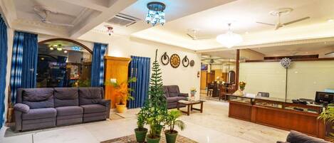 A spacious living area with a sofa, a coffee table, and a reception desk.