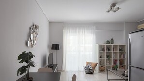 A modern kitchen with a dining area, a potted plant, and a bookshelf. - Athenian Comfort Apartments (Zografos)