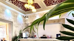 A reception area with a marble floor, a reception desk, and a chandelier. - Hôtel Ayachi (Tunis)