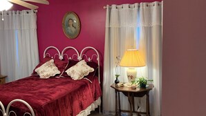 Une chambre à coucher avec un lit, une table de chevet avec une lampe et un ventilateur de plafond.