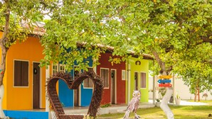 A colorful building with a heart-shaped entrance and a signpost with directional arrows. - Pousada Estrela da manhã (Barreirinhas)