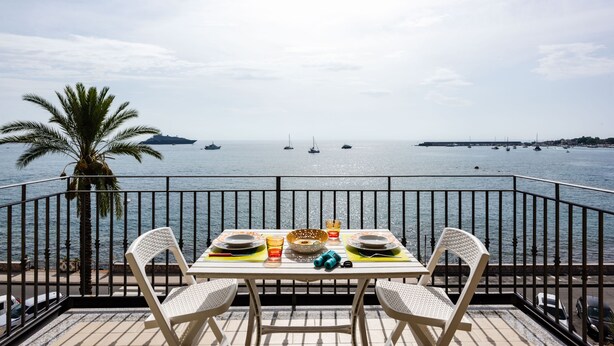 A dining table with chairs on a balcony overlooking the sea. - Naxos Bay View With Terrace by Wonderful Italy (Giardini Naxos)