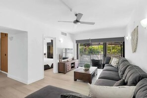 A modern living room with a sofa, coffee table, and a ceiling fan.