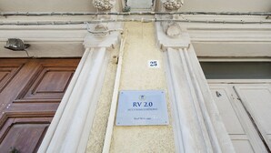 A building entrance with a sign reading "RV 2.0 Accommodations" and a number "25" above it. - RV 2.0  (Messina)