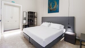 A modern bedroom with a large bed, a wardrobe, a bedside table, and a wall-mounted artwork. - RV 2.0  (Messina)