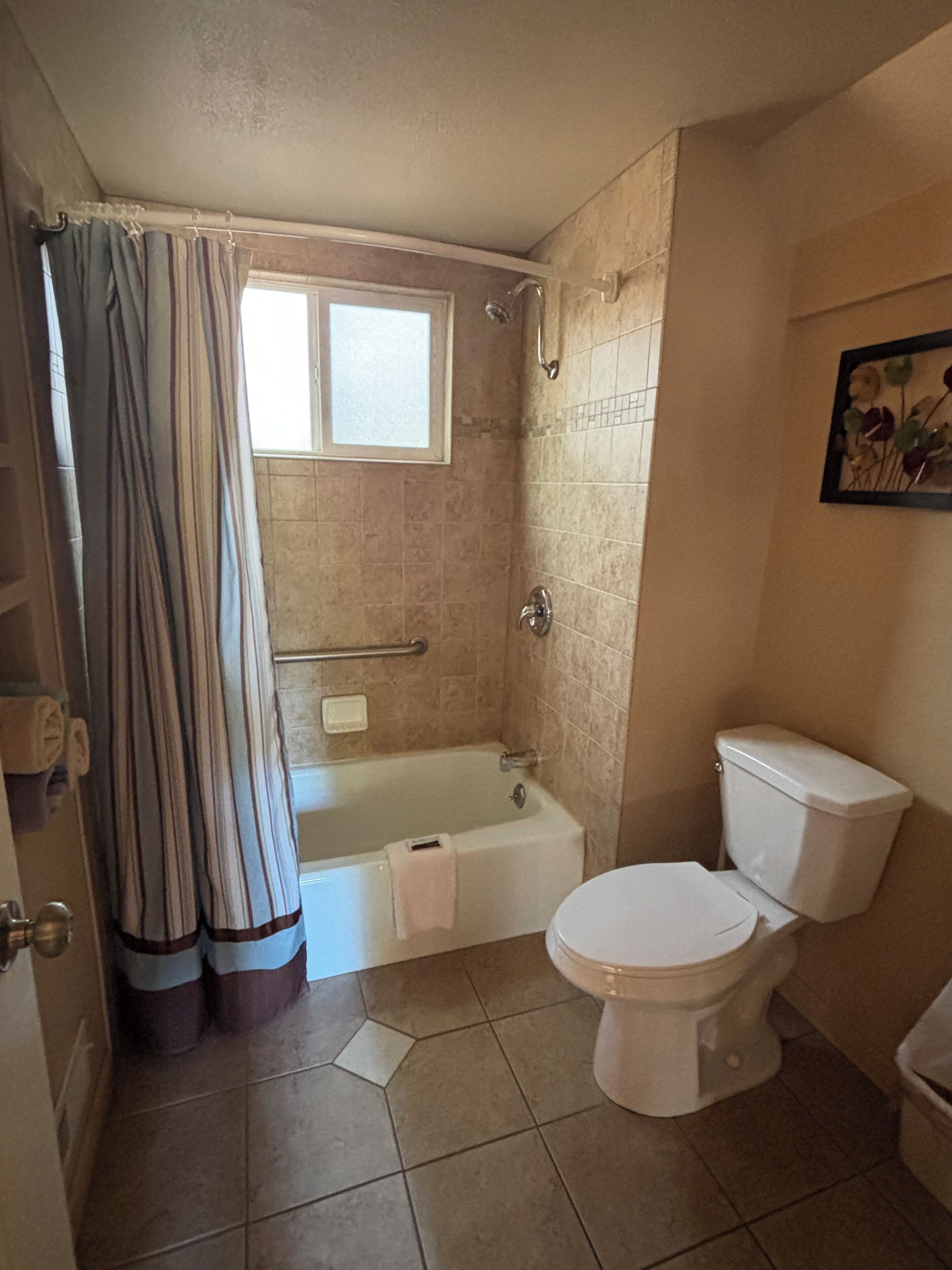 A bathroom with a bathtub, toilet, and shower.