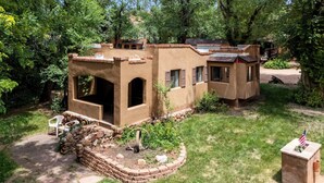 Un rústico edificio de adobe con un camino de piedra que lleva a una zona de estar.