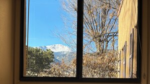 Una ventana con vista a una montaña y árboles.