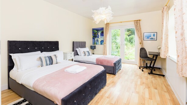 A bedroom with two beds, a desk, and a chair. - 6 bedroom house near Edgbaston Stadium (Birmingham)
