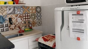 Una cucina compatta con forno a microonde, fornello e lavello.