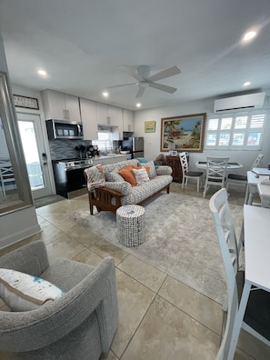 Relax in a comfortable living space with a central seating area, dining table, and modern kitchen.