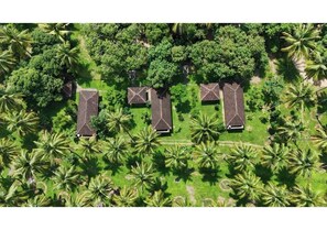 Luchtbeeld van een resort met drie gebouwen, omringd door palmbomen.