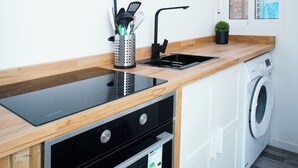 Una cucina moderna con forno a incasso, microonde, lavello e lavatrice.