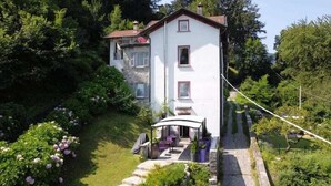 A two-story house with a covered patio and a garden. - La collinettabeb (Bisignano)