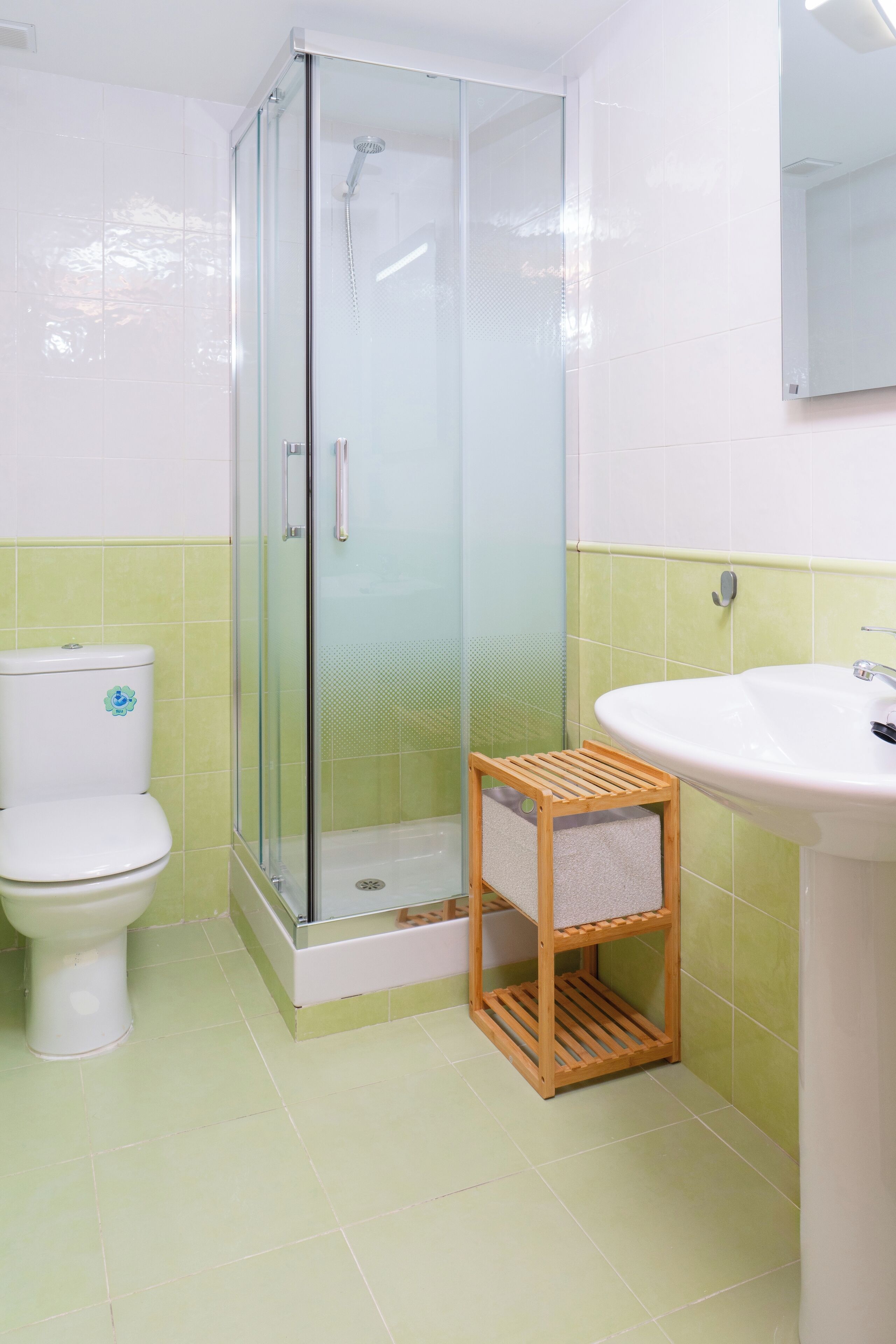 Un baño con ducha de vidrio, inodoro y lavamanos.
