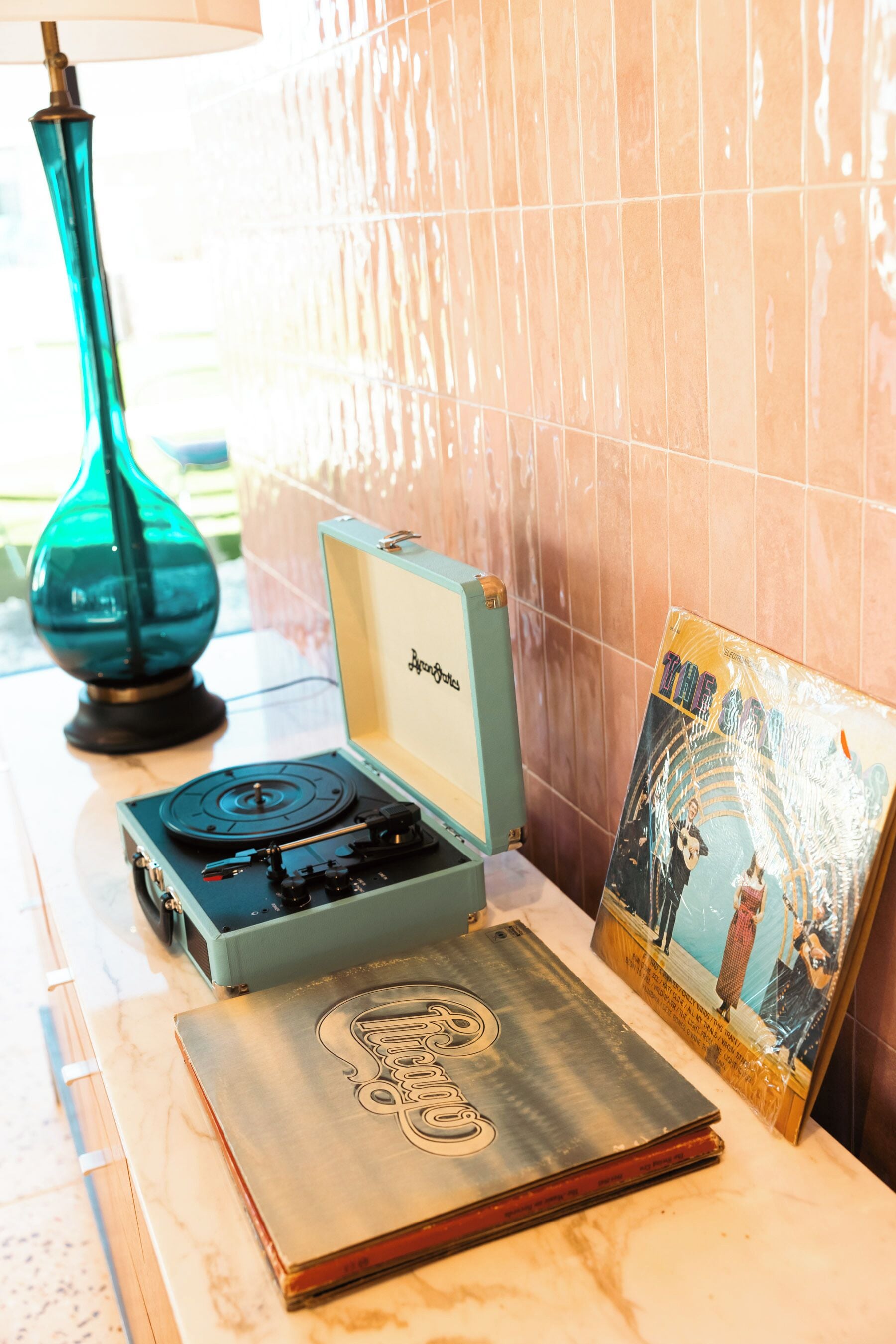 A turntable, a record, and a framed picture on a marble surface.