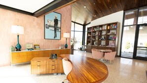 A modern interior with a wooden desk, a cushioned chair, a wooden cabinet, and a bookshelf. - Interstate Inn (Stephenville)