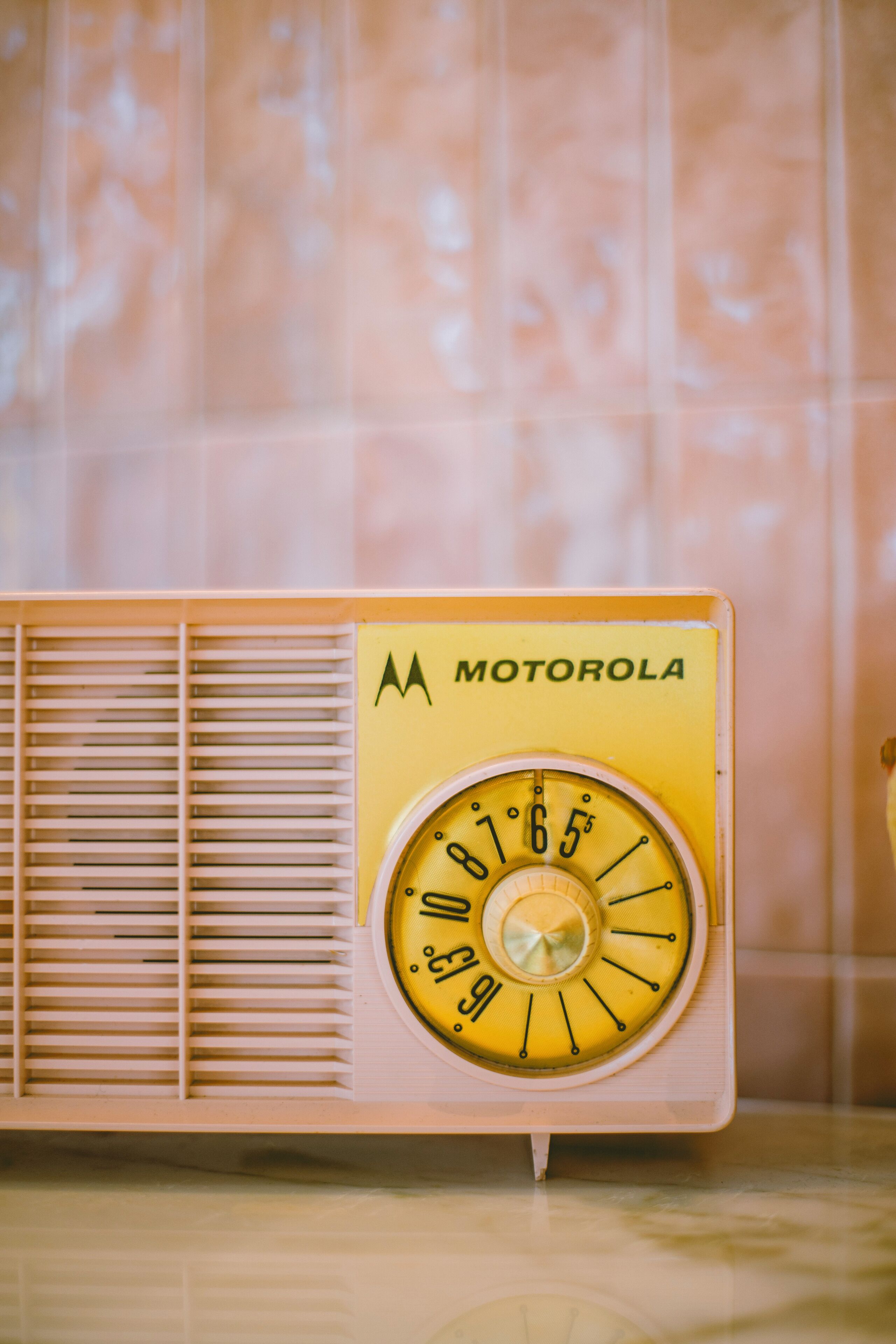 A vintage Motorola radio with a yellow dial and a wooden panel.