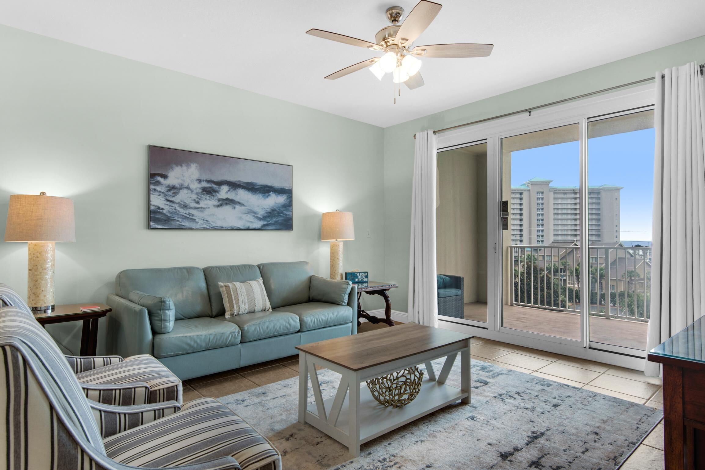 A living room with a sofa, a coffee table, and a painting on the wall.