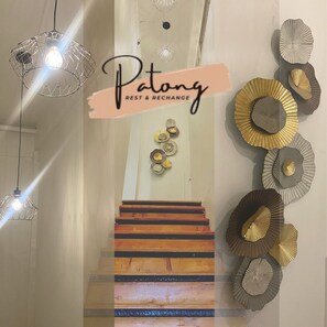 A staircase with wooden steps and a wall with decorative plates. - Patong Rest & Recharge  (Patong)