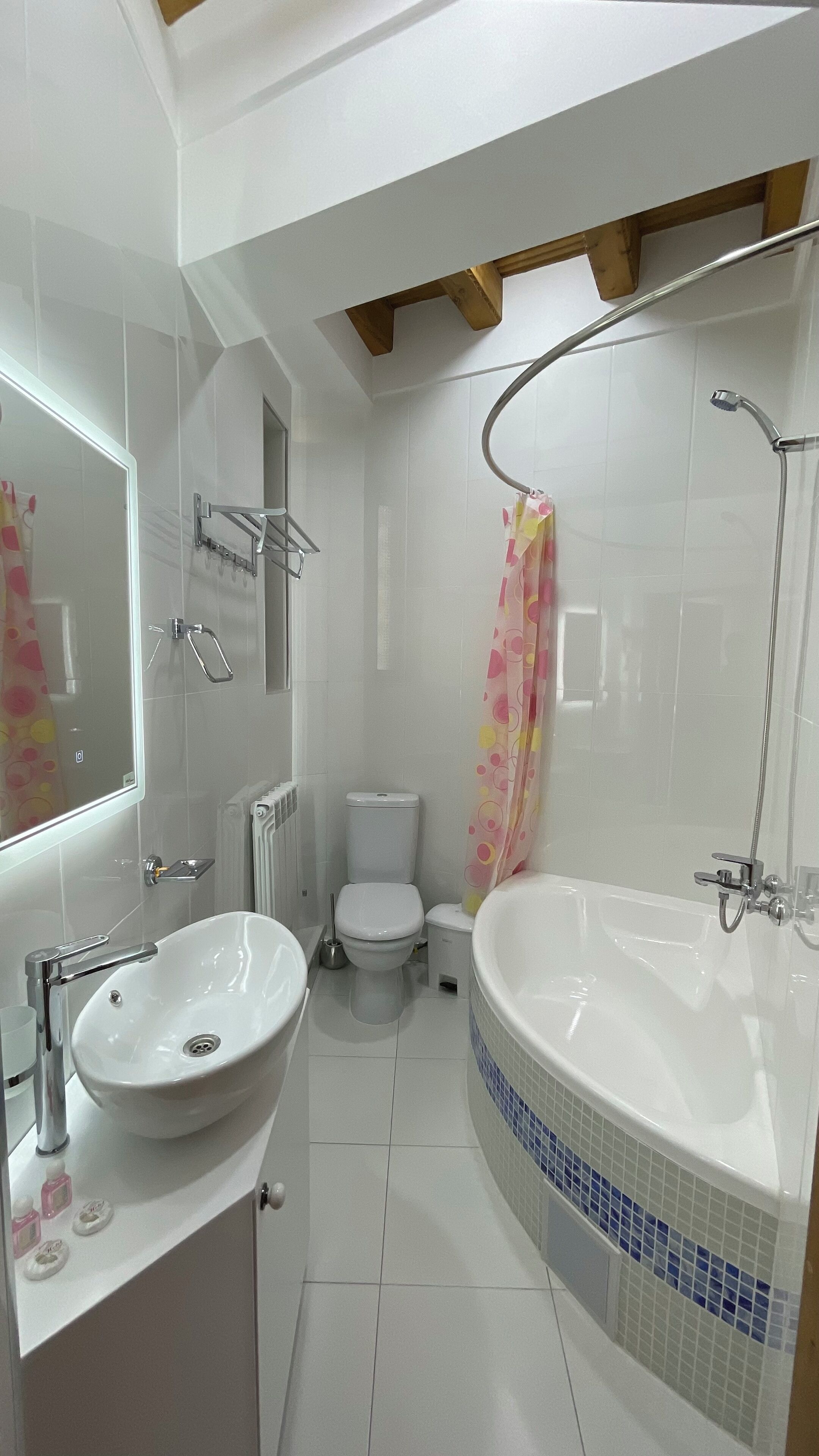 A modern bathroom with a freestanding bathtub, a sink, a toilet, and a shower curtain.