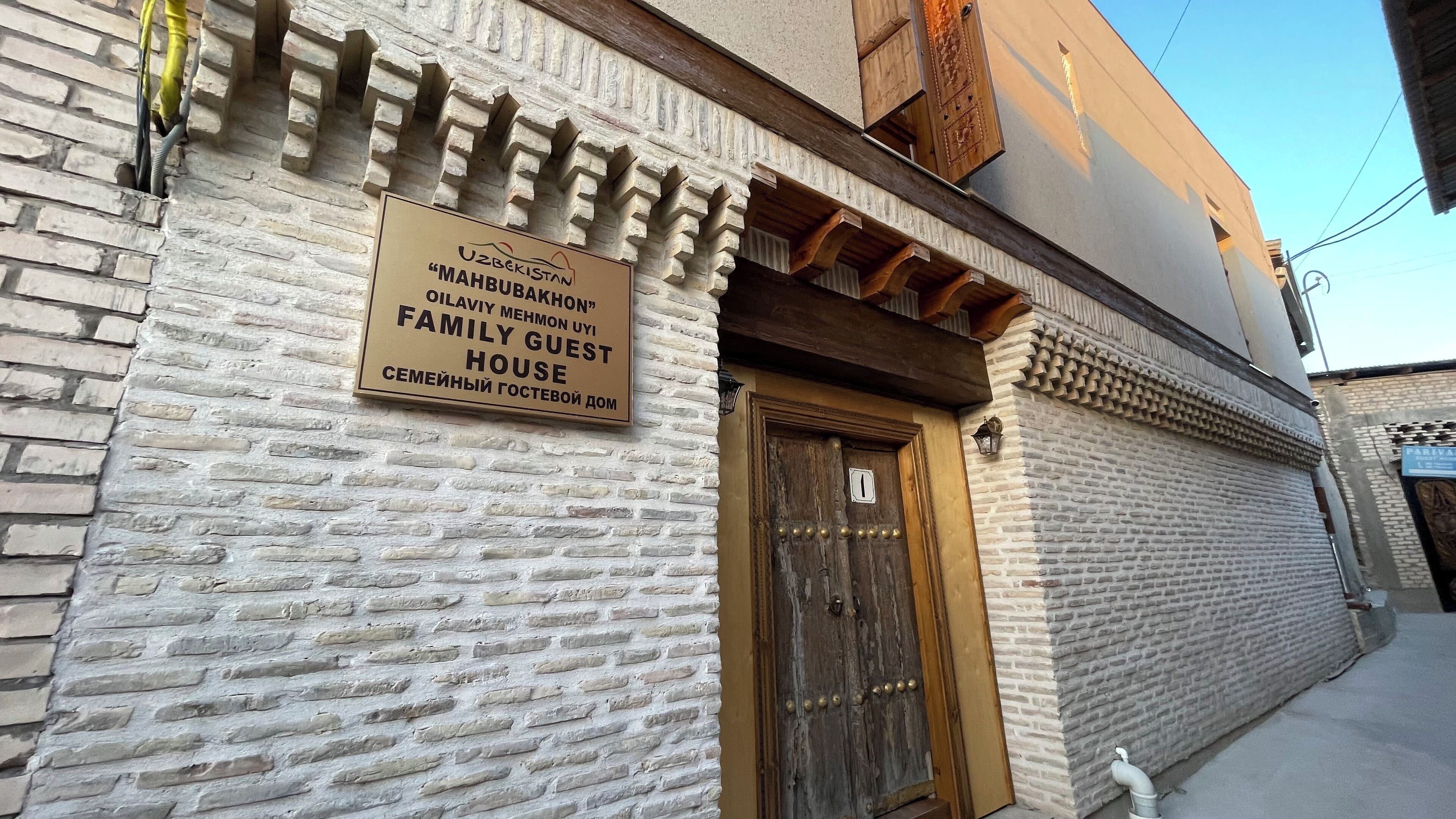 A building with a sign indicating it is a family guest house in Uzbekistan.