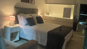 A hotel room with a bed, bedside table, lamp, chair, and a television. - MORDO DA SERRA (Paty do Alferes)