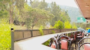 A covered outdoor seating area with chairs and a sign for XAVINA PHARMACY. - Hirwa Avenir (Kigali)
