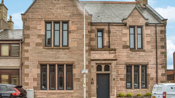 A two-story stone building with a gabled roof, multiple windows, and a door. - Beautiful One Bedroom Apartment with additional Sofa Bed, Arbroath centre. (Arbroath)