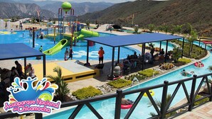 Un parc aquatique doté de plusieurs piscines, de toboggans et d’un espace de repos couvert.