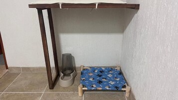 Un espacio reducido y cerrado con una mesa de madera y una cama para mascotas.