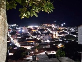 Vista nocturna de un paisaje urbano con edificios y una mezquita con cúpula.