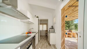 Una cucina moderna con piano cottura integrato, lavastoviglie e vista sul patio esterno.