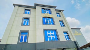 Un immeuble à plusieurs étages doté d’une architecture moderne, avec un logo et une enseigne bien visibles pour l’hôtel Light Spring.